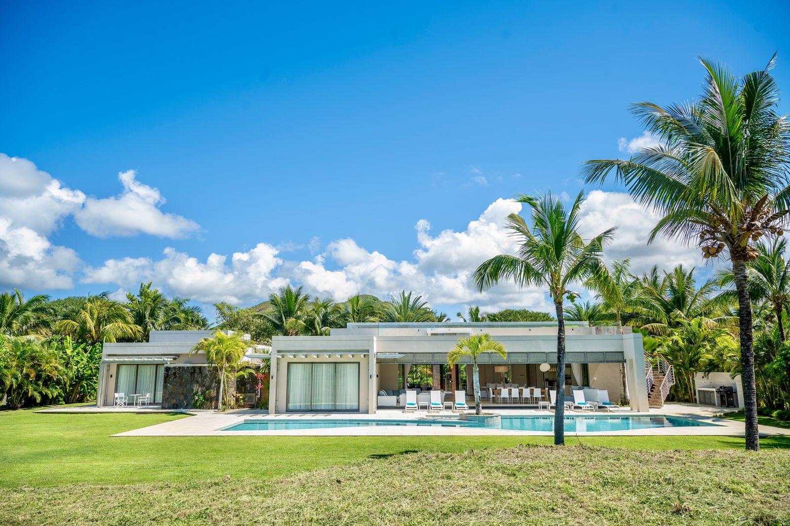 La villa entière et sa piscine, vues depuis la pelouse